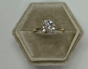Gold ring with diamond in velvet box.