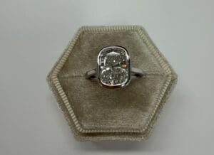 Bezel-set cushion diamond ring in velvet box