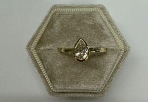 Pear-shaped diamond ring in hexagonal velvet box