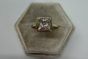 Square-cut diamond ring on hexagonal velvet box