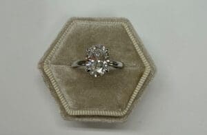 Oval diamond ring in hexagonal velvet box
