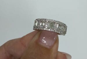 Fingertip holding stepped-cut diamond band